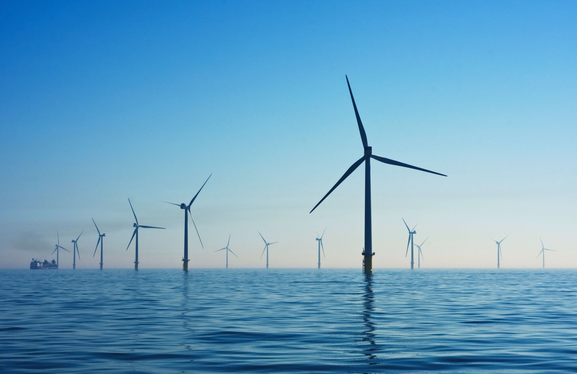 various off-shore wind turbines in the sea, blue sky and sea surface
